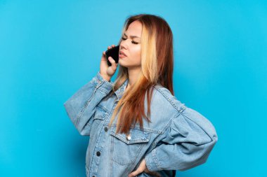 Genç bir kız cep telefonunu izole edilmiş arka planda kullanıyor.