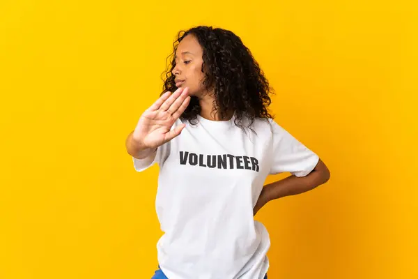 stock image Teenager cuban volunteer girl isolated on yellow background making stop gesture and disappointed