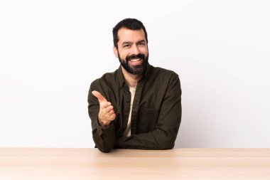 Masada sakallı, beyaz bir adam iyi bir anlaşma için el sıkışıyor..