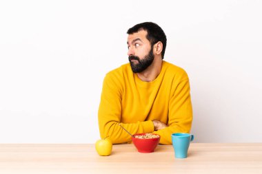 Masada kahvaltı yapan beyaz bir adam şüpheli hareketler yapıyor..