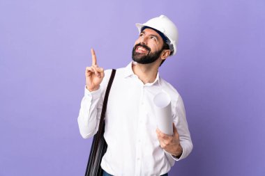 Miğferli genç bir mimar, elinde izole edilmiş mor arka plan planları var. Harika bir fikir.