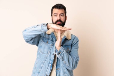 Sakallı, soyutlanmış bir geçmişi olan beyaz bir adam jest yapıyor.