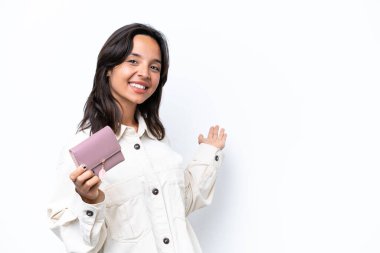 Beyaz arka planda izole edilmiş cüzdanı tutan genç İspanyol kadın davet etmek için elini yana uzatıyor.