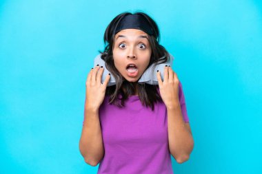 Şişirilebilir Seyahat Yastığı 'na sahip genç beyaz kadın mavi arka planda tek başına zaferi kutluyor.