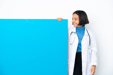 Beyaz arka planda izole edilmiş büyük bir afişi olan genç ırk doktoru kadın.
