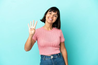 Genç melez kadın mavi arka planda izole edilmiş mutlu ve parmaklarıyla dörde kadar sayıyor.