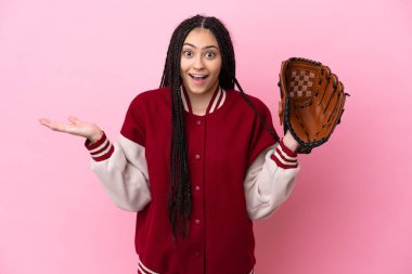 Beyzbol eldivenli genç oyuncu pembe arka planda izole edilmiş ve şok olmuş bir yüz ifadesi var.