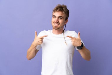 Mor arka planda soyutlanmış, gururlu ve kendini beğenmiş sarışın genç adam.