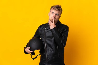 Motosiklet kasklı bir adam sarı arka planda izole edilmiş.
