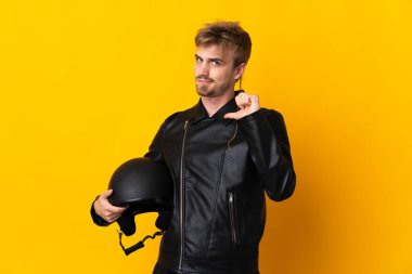 Motosiklet kasklı bir adam sarı arka planda kendini beğenmiş ve gururlu.