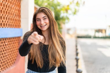 Genç, güzel, beyaz bir kadın kendine güvenen bir ifadeyle seni işaret ediyor.