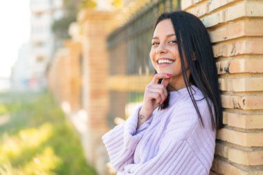Açık havada gülümseyen genç bir kadın