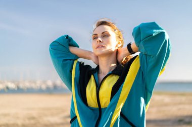 Dışarıdaki genç kadın spor giysisi giyiyor.