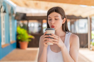 Kafede kahve içen genç bir kadının portresi