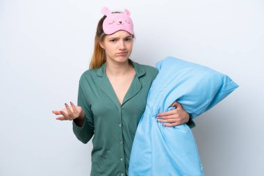 Genç Rus kız pijamalarıyla beyaz arka planda izole edilmiş ve omuzlarını kaldırırken şüpheyle hareket ediyor.