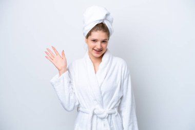 Bornozlu genç Rus kız beyaz arka planda izole edilmiş mutlu bir ifadeyle selam veriyor.