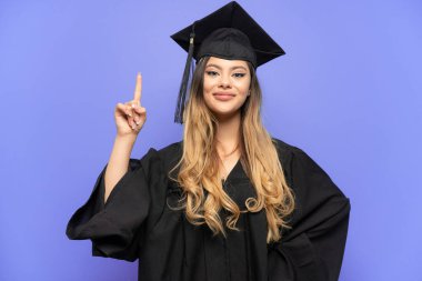 Genç üniversite mezunu Rus kız beyaz arka planda izole edilmiş. Harika bir fikre işaret ediyor.