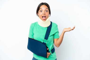 Boyunluk takan genç İspanyol kadın beyaz arka planda izole edilmiş ve yüzünde şok ifadesi olan bir askı takıyor.