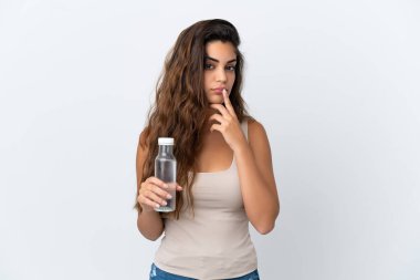Beyaz arka planda izole edilmiş bir şişe suyu olan beyaz bir kadın yukarı bakarken şüpheleri var.