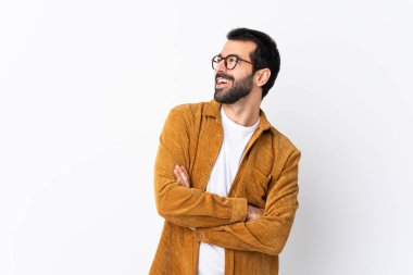 Sakallı, beyaz arka planda kadife ceket giyen beyaz, mutlu ve gülümseyen beyaz bir adam.