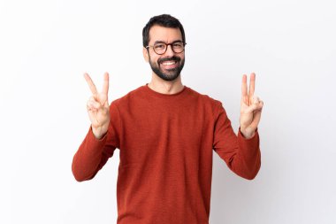 İzole edilmiş beyaz arka planda sakallı, beyaz, beyaz, yakışıklı bir adam iki eliyle zafer işareti gösteriyor.