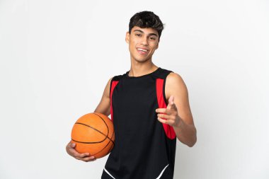 Basketbol oynayan ve ön tarafı işaret eden izole edilmiş beyaz arka planı olan genç bir adam.