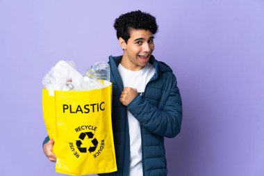Genç Venezuelalı bir adam elinde bir çanta dolusu plastik şişeyle zaferi kutluyor.