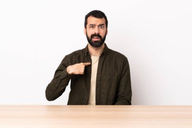 Masada sakallı beyaz bir adam kendini işaret ediyor..