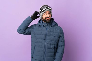 İzole edilmiş mor arka planda snowboard gözlüklü kayakçı şüpheleri var.