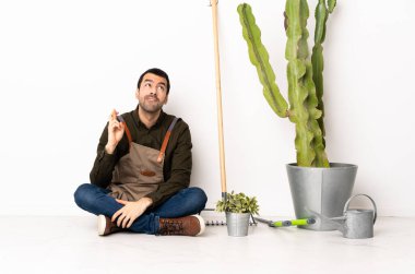 Bahçıvan içeride oturuyor. Parmakları çapraz ve en iyisini diliyor.