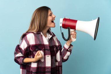 Genç Slovak kadın mavi arka planda izole edilmiş bir şekilde megafonla bir şey duyurmak için bağırıyor.
