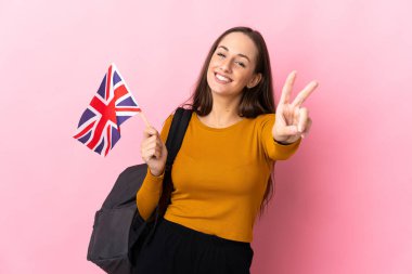 Birleşik Krallık bayrağını tutan genç İspanyol kadın gülümsüyor ve zafer işareti gösteriyor.