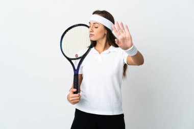 İzole edilmiş beyaz arka planda genç bayan tenisçi durdurma hareketi yapıyor ve hayal kırıklığına uğruyor