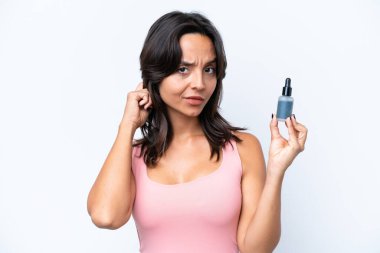 Beyaz arka planda serumu tutan genç İspanyol kadının şüpheleri var.