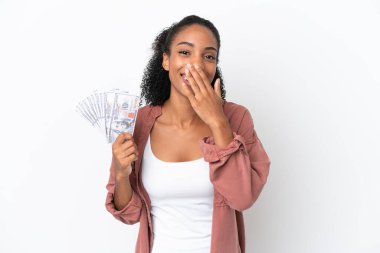 Genç Afrikalı Amerikalı bir kadın beyaz arka planda izole edilmiş bir sürü para alıyor mutlu ve ağzı kapalı gülümsüyor.