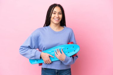 Saçları örgülü genç bir kız izole edilmiş pembe bir arka planı var.