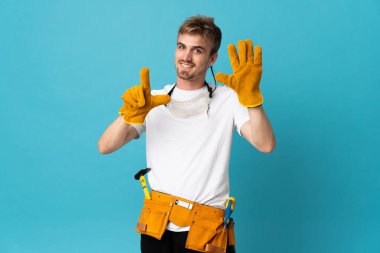 Genç elektrikçi tecrit edilmiş duvarın üzerinden yedi parmaklı sayıyor.