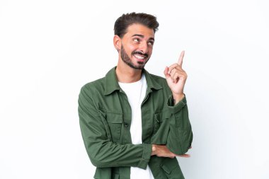 Beyaz arka planda izole edilmiş genç beyaz adam harika bir fikre işaret ediyor