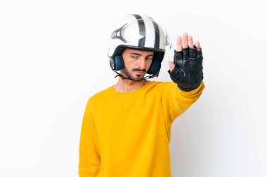 Beyaz arka planda izole edilmiş motosiklet kasklı beyaz bir adam dur hareketi yapıyor ve hayal kırıklığına uğruyor.