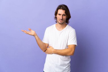 Mor arka planda izole edilmiş genç yakışıklı adamın şüpheleri var.