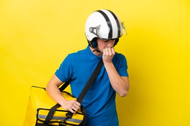 Termal sırt çantalı genç Brezilyalı adam sarı arka planda izole edilmiş. Şüpheleri var.