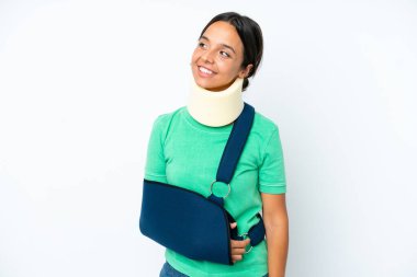 Boyunluk takan ve askı takan genç İspanyol kadın beyaz arka planda izole edilmiş bir şekilde yukarı bakarken bir fikir düşünüyor.