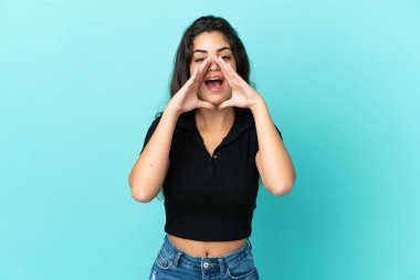 Beyaz bir kadın mavi arka planda izole edilmiş bağırıyor ve bir şeyler söylüyor.
