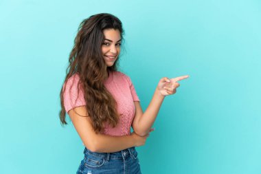 Mavi arka planda izole edilmiş genç, beyaz bir kadın var.