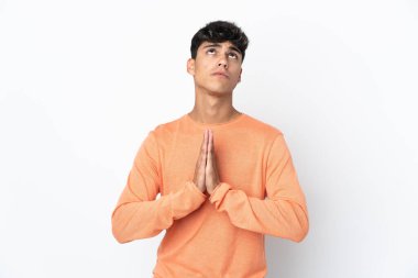 İzole edilmiş beyaz arka planı olan genç bir adam avuç içlerini bir arada tutuyor. İnsan bir şey ister.