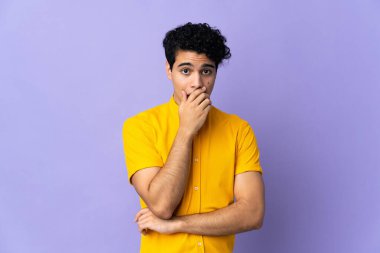 Genç Venezuelalı adam mor arka planda izole edilmiş.