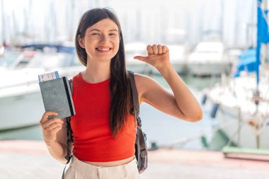 Genç, güzel Ukraynalı bir kadın elinde pasaportuyla dışarıda gururlu ve kendini beğenmiş.