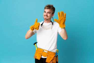 Genç elektrikçi, izole edilmiş duvarın üzerinden altı parmaklı sayım yapıyor.