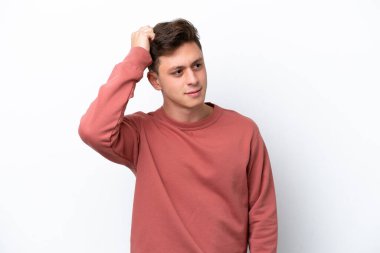 Genç, yakışıklı Brezilyalı bir adam beyaz arka planda izole edilmiş, kafası kaşınırken şüpheleri var.