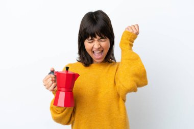 Beyaz arka planda kahve demliği tutan genç melez kadın zaferi kutluyor.